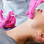 Attractive young woman gets cosmetic face injection