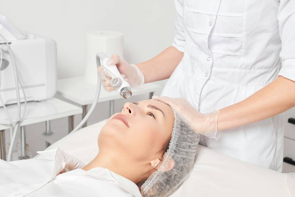 Beautician makes facial gas liquid oxygen serum epidermal peeling for rejuvenation woman face