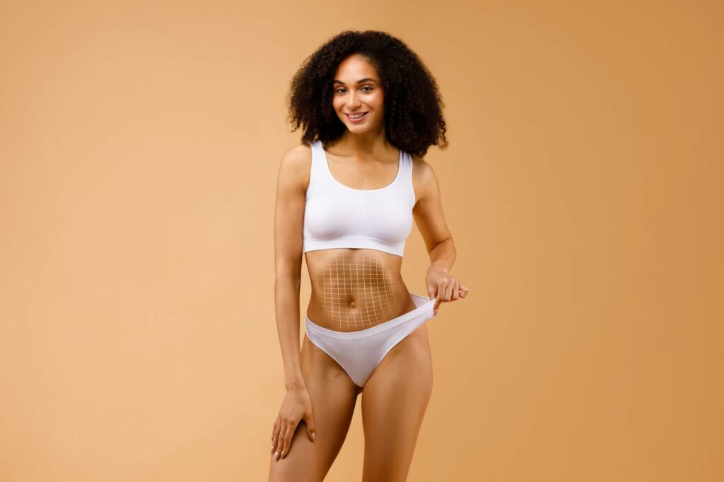 Slender black lady in underwear with net on her belly