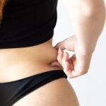 selective focus girl s hand measuring her fat folds scaled aesthetic medical spa treatment McLean VA En Santé Med