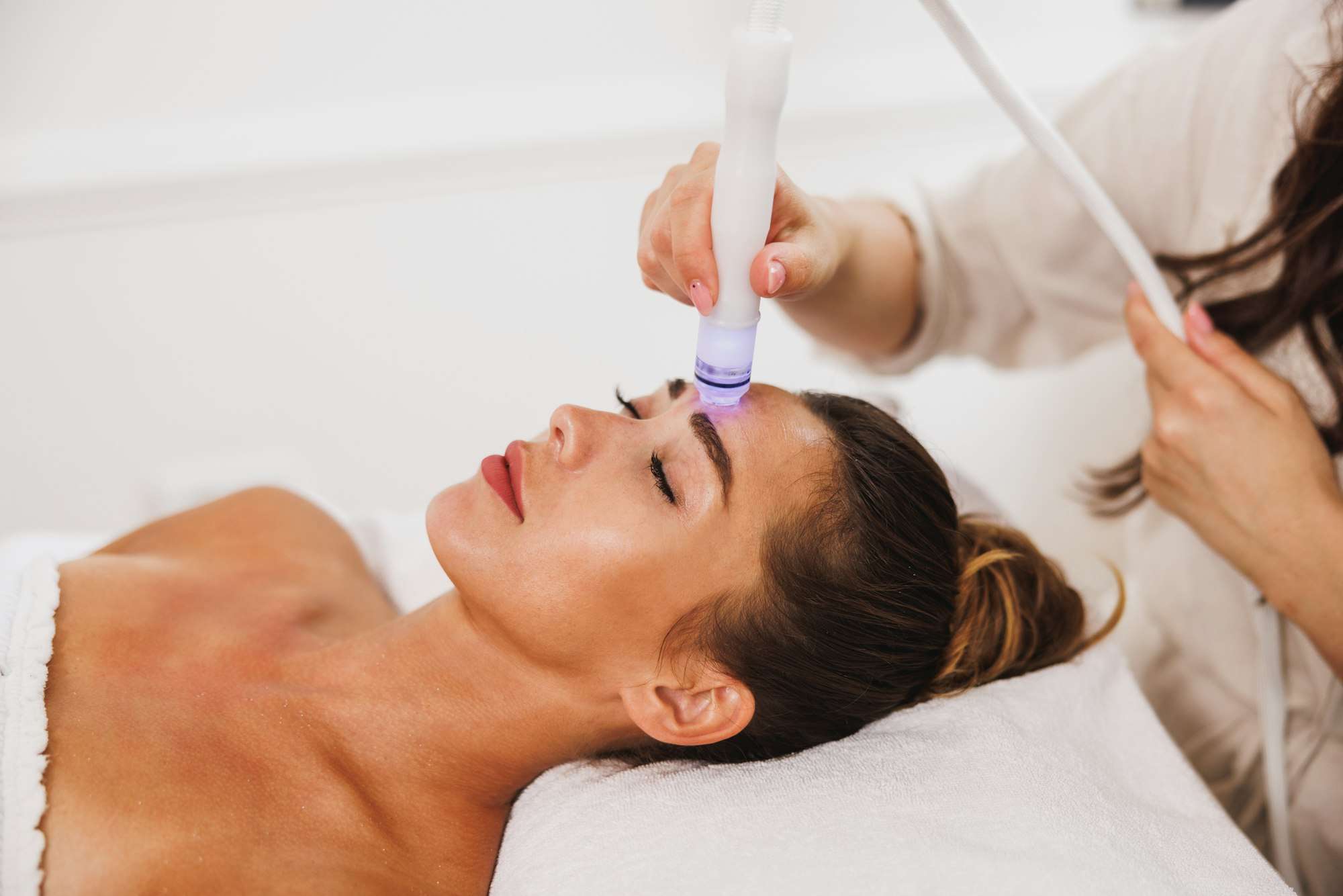 beauty therapist performing hydrafacial procedure on woman aesthetic medical spa treatment McLean VA En Santé Med