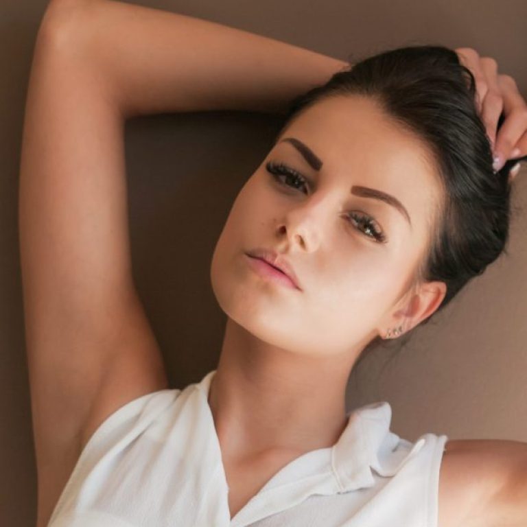 portrait beautiful woman with hand hair standing against wall home scaled e1767653072988 aesthetic medical spa treatment McLean VA En Santé Med