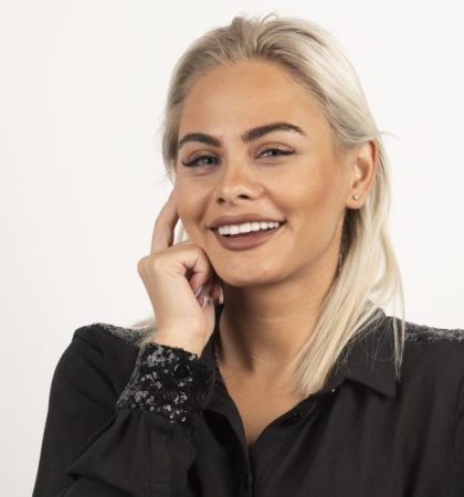 Portrait of smiling woman in black shirt posing on white background. High quality photo