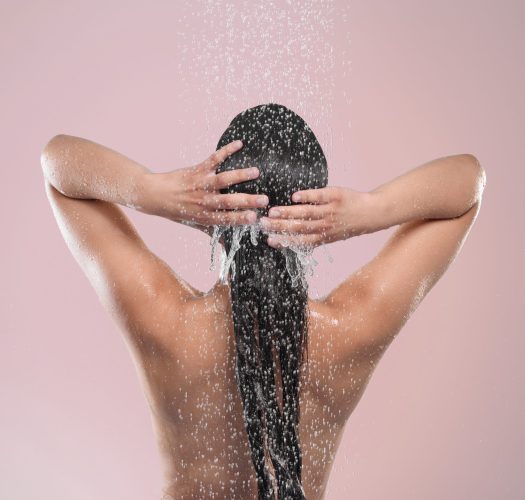 woman hair back studio with water pink background relaxing cleaning model washing grooming hygiene female person wet self care showering wellness routine scaled aesthetic medical spa treatment McLean VA En Santé Med