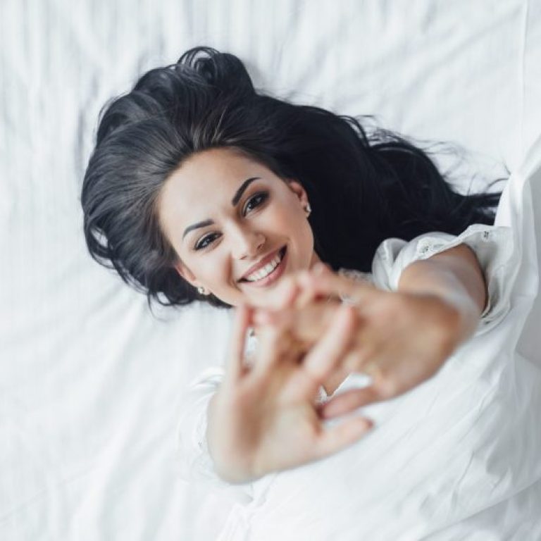 young beautiful brunette happy girl lies her bed waking up morning sweating top view scaled e1767629334778 aesthetic medical spa treatment McLean VA En Santé Med